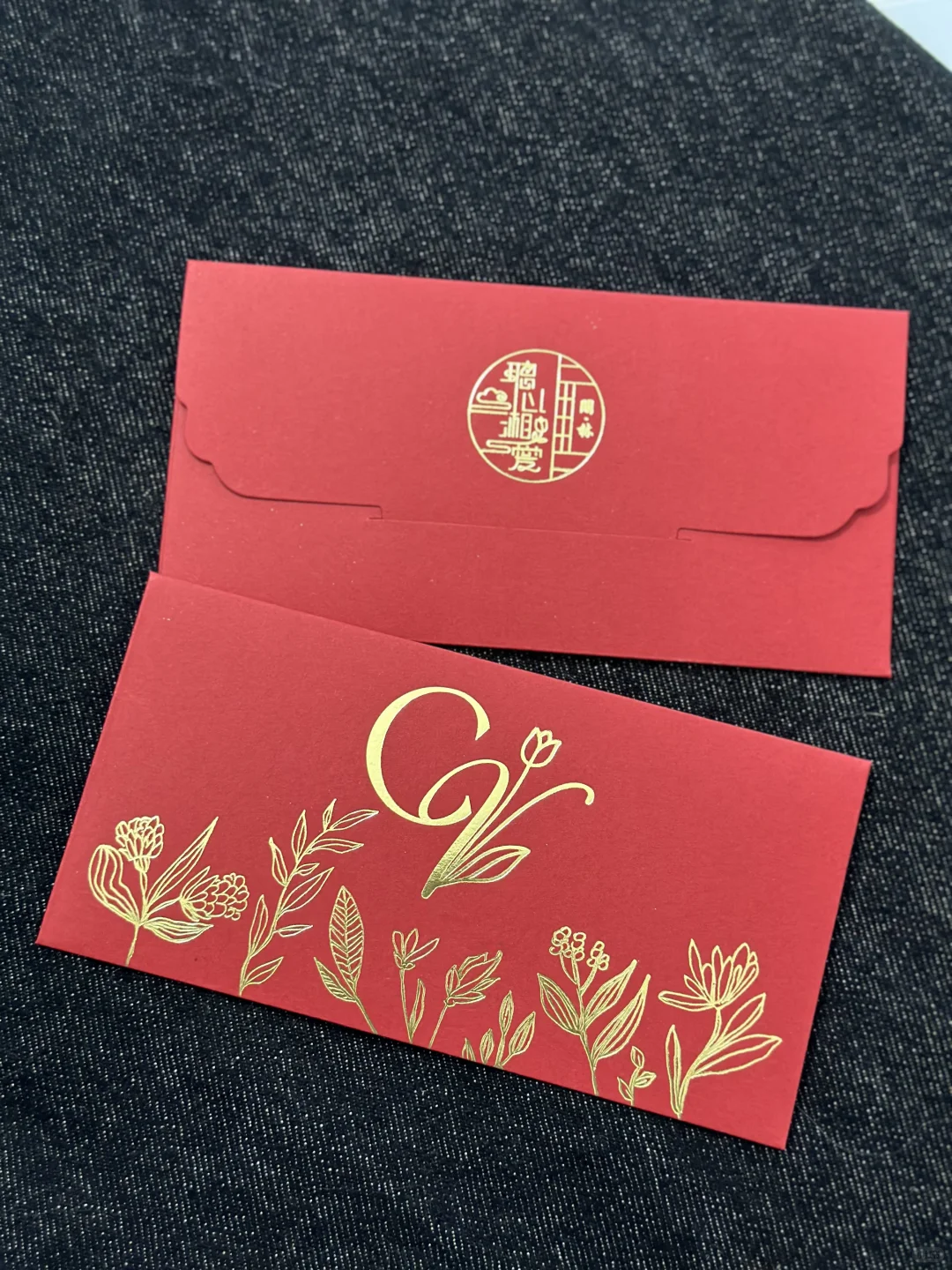 红色花卉字母西封红包，正面金色花卉线条与背面闭合封口同框。